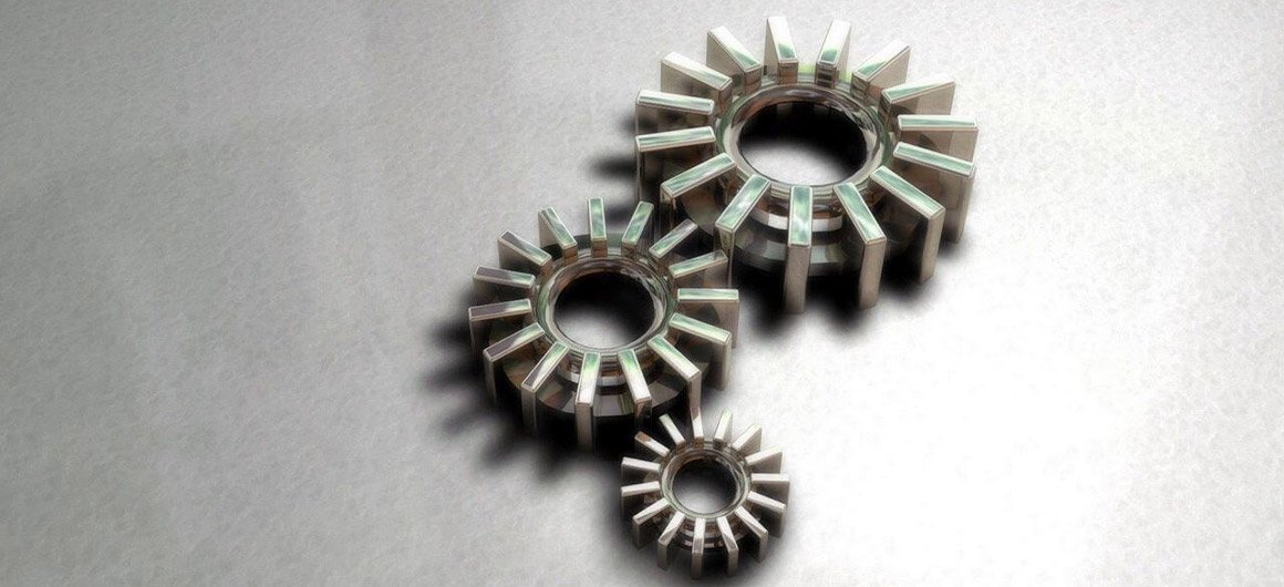 Trois engrenages métalliques futuristes de tailles différentes sur fond gris, illustrant un concept technologique ou mécanique